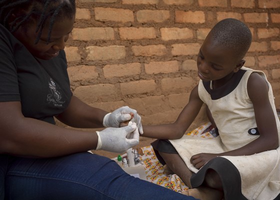 Rumbi (9) wordt getest op hiv door een gezondheidsmedewerker van Aidsfonds
